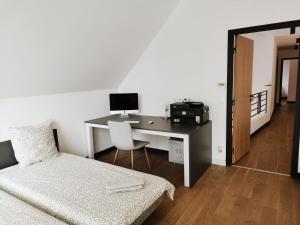 Schlafzimmer mit einem Schreibtisch, einem Computer und einem Bett in der Unterkunft VILLA CONTEMPORAINE in Voulangis