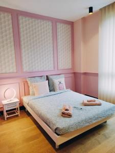 une chambre rose avec un lit et une tête de lit dans l'établissement VILLA CONTEMPORAINE, à Voulangis