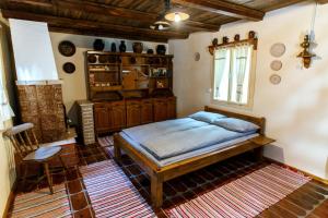 1 dormitorio con 1 cama y 1 silla en Fantázia Kulcsosház, en Ciumani