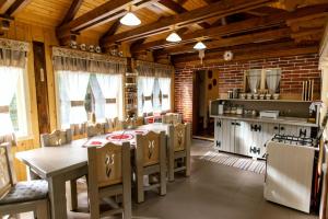 kuchnia ze stołami i krzesłami w pokoju w obiekcie Fantázia Kulcsosház w mieście Ciumani