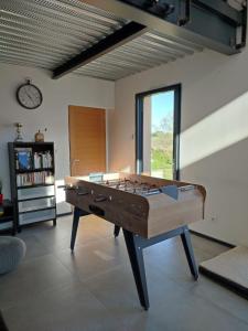 a pool table in a living room with a clock at Les Terrasses du Phenix in Saint Alban Auriolles