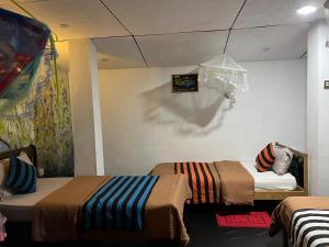 een kamer met 2 bedden en een schilderij aan de muur bij Noname Hostel And Cafe in Ella