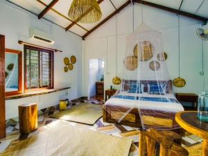 Cette grande chambre comprend un lit et une table. dans l'établissement Kraoul Seh - Horse Riding Cambodia, à Kampot