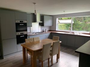 a kitchen with a wooden table and chairs and a kitchen with a sink at Modern Room Close to Warwick University in Canley