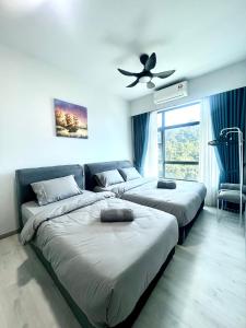 sypialnia z 3 łóżkami i wentylatorem sufitowym w obiekcie Botiza Suites at Jesselton Quay w mieście Kota Kinabalu