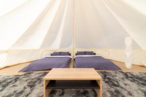 two beds in a marquee tent with a table at Glamchette Okayama -Glamping & Auto Camp- - Vacation STAY 44598v in Mimasaka