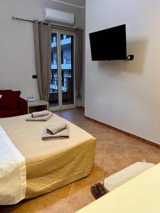 una camera con 2 letti e una TV a schermo piatto di Tutti i Comfort Giuliano's Apartment a Messina