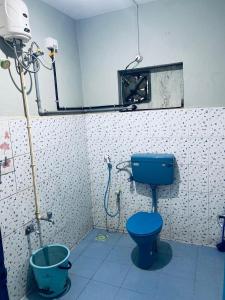 a bathroom with a blue toilet in a room at Varkala Vibe in Varkala