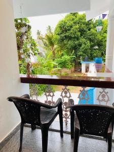 a table and two chairs in front of a window at Varkala Vibe in Varkala