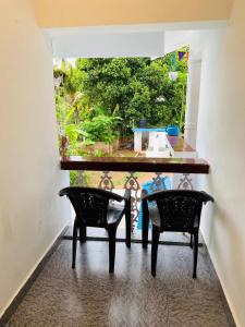 a table and two chairs in a room with a window at Varkala Vibe in Varkala