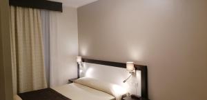 a bedroom with a bed with lights on it at Hotel Boccascena in Genoa
