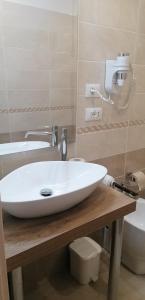 a bathroom with a white sink and a toilet at Hotel Boccascena in Genoa