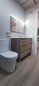 y baño con aseo, lavabo y espejo. en Apartamento 4 habitaciones 2 baños Ciudad de las Ciencias VT-55209-V, en Valencia