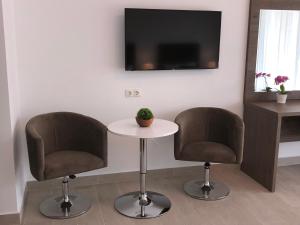 twee stoelen en een tafel in een kamer met een tv bij Vila Navona in Saturn