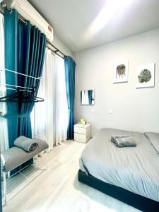 sypialnia z niebieskimi zasłonami, łóżkiem i oknem w obiekcie Botiza Suites at Jesselton Quay w mieście Kota Kinabalu