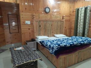 a bedroom with a bed and a clock on the wall at THE GROOVE GARDEN DHANOLTi in Dhanaulti
