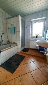 łazienka z wanną, umywalką i oknem w obiekcie Zweite Heimat Bamberg w mieście Stegaurach
