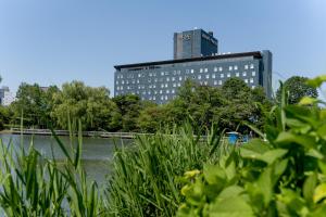 a tall building in front of a body of water at Sapporo Park Hotel in Sapporo