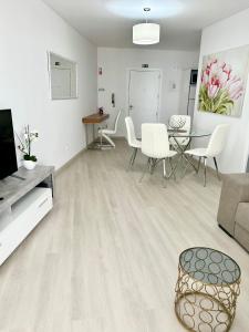 a living room with a couch and a table and chairs at Lido Casa by Olá Madeira in Funchal +23 photos