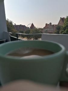 a cup of coffee sitting on top of a balcony at Dream Loft Podwale Staromiejskie in Gdańsk