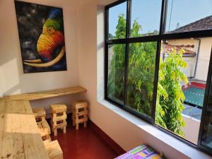 een kamer met een tafel en stoelen en een groot raam bij CEYLON STAYZ in Colombo