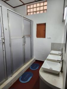 a bathroom with three sinks and a counter with blue mats at CEYLON STAYZ in Colombo