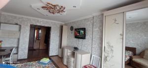 ein kleines Wohnzimmer mit einem Tisch und einem Sofa in der Unterkunft Кенесары Жубанова in Astana