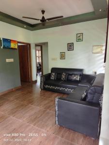 坎努尔Sunshine Service Villa的配有沙发和吊扇的客厅