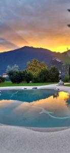 a swimming pool with a sunset in the background at Borgo San Nazzaro in Riva del Garda