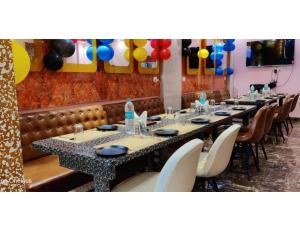 una fila de mesas en un restaurante con globos en Hotel RREAMSO International, Muzaffarpur en Muzaffarpur