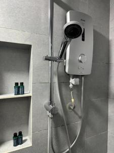 a shower in a bathroom with a camera on the wall at Botiza Suites at Jesselton Quay in Kota Kinabalu