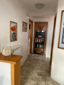 un pasillo con una mesa y un estante para libros en Adamo&Eva Guesthouse, en Torre del Greco