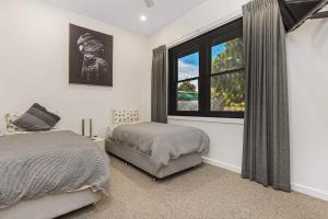 een slaapkamer met 2 bedden en een raam bij Cosy Retreat on Forest (Non Smoking) - Sleeps 6 in Bendigo