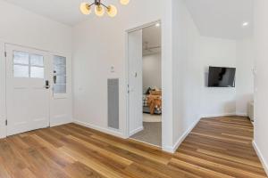 een lege woonkamer met witte muren en houten vloeren bij Cosy Retreat on Forest (Non Smoking) - Sleeps 6 in Bendigo