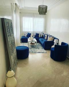 sala de estar con sofá azul y sillas azules en Petit appartement 68m2 quartier Bourgogne en Casablanca
