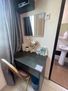a bathroom with a counter with a sink and a mirror at Intanova Hotel in Teluk Intan