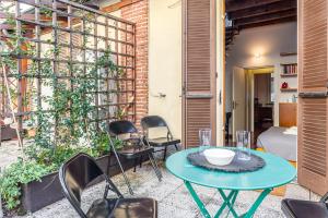 a patio with a table and chairs and a bed at Duomo-Porta Romana "Casa del Pittore" in Milan