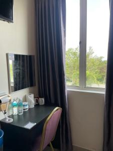a desk in a room with a window at Intanova Hotel in Teluk Intan