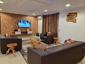ein Wohnzimmer mit 2 Sofas und einem Flachbild-TV in der Unterkunft Igbalode Luxury Apartment in Ibadan