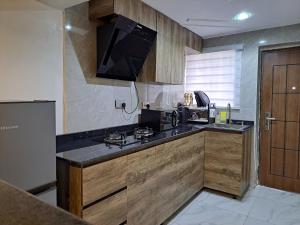 a kitchen with wooden cabinets and a black counter top at Igbalode Luxury Apartment in Ibadan