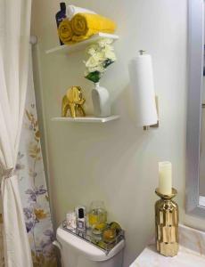 een badkamer met een toilet en een vaas met bloemen bij Exotic Room in Hampton
