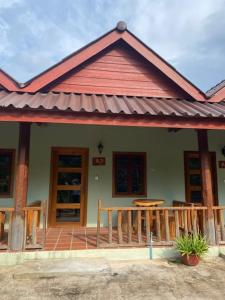 une maison avec une terrasse couverte et un toit dans l'établissement Kraoul Seh - Horse Riding Cambodia, à Kampot