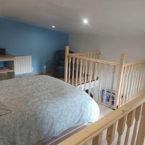 a bedroom with a large bed and a crib at Nouveau Loft T2, connecté internet fibre et wifi in Saint-Quentin