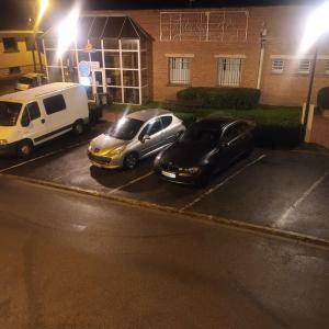 two cars parked in a parking lot at night at Nouveau Loft T2, connecté internet fibre et wifi in Saint-Quentin