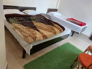 Cama en habitación con alfombra verde en Hotel Srishty Choice, Rudraprayag, en Rudraprayāg