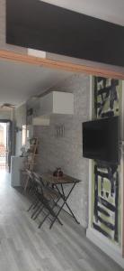a living room with a table and a flat screen tv at SALTILLO ALTO WHITE STUDIO in Torremolinos