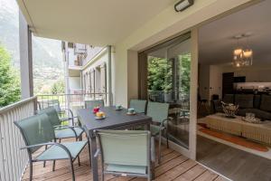 een balkon met een tafel en stoelen en een woonkamer bij WHITE PEARL in Chamonix-Mont-Blanc