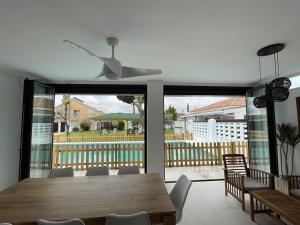 a dining room with a table and a ceiling fan at Villa Jiménez in Griñón