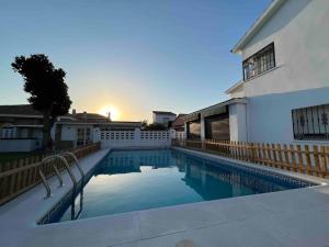 a swimming pool in front of a white building at Villa Jiménez in Griñón