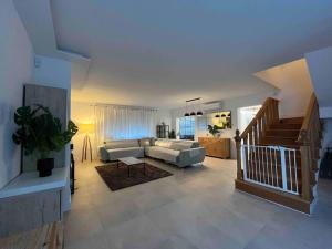 a large living room with a couch and a staircase at Villa Jiménez in Griñón +21 photos